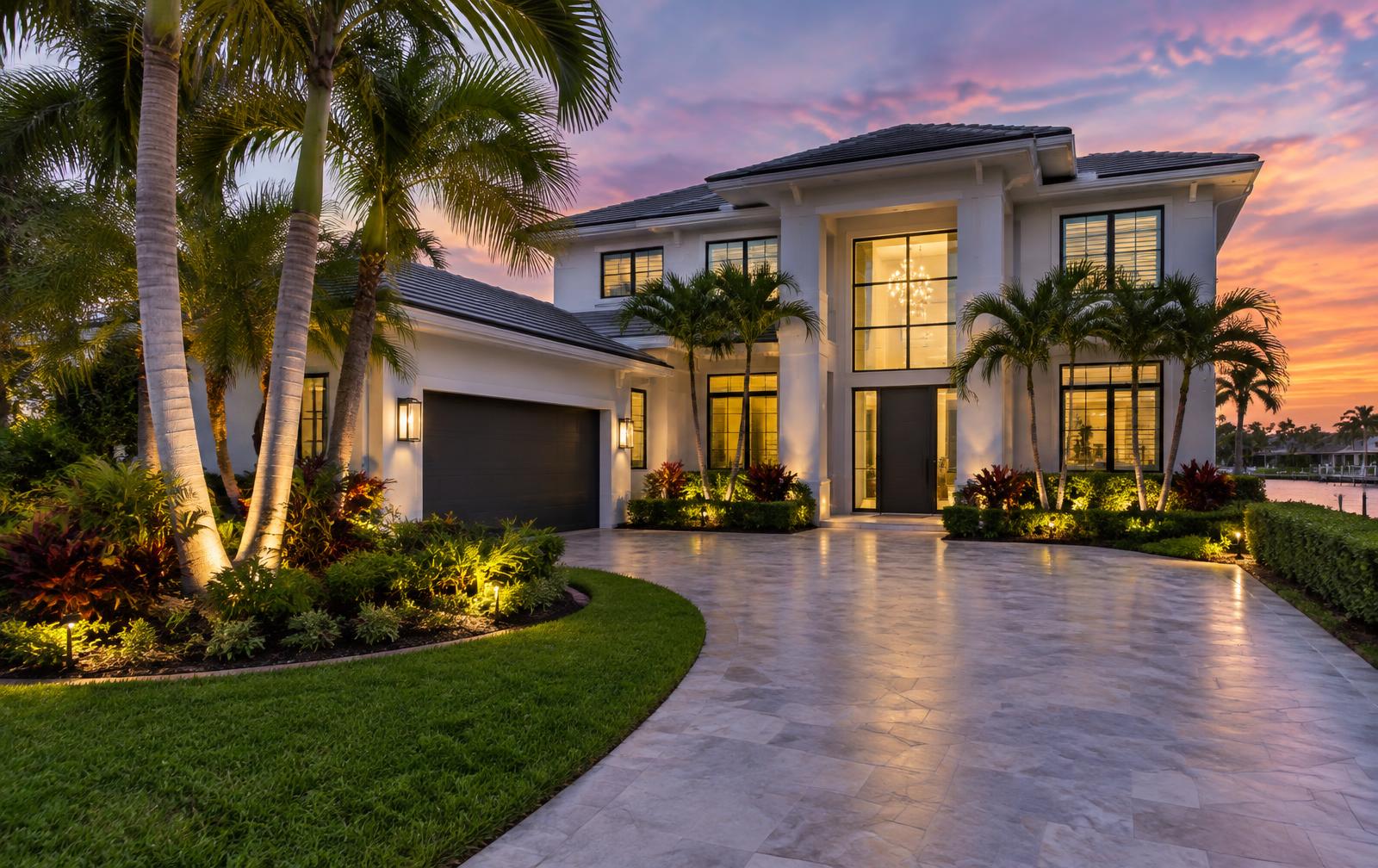 Freshly remodeled South Florida home exterior with new paint, windows and lighting at twilight